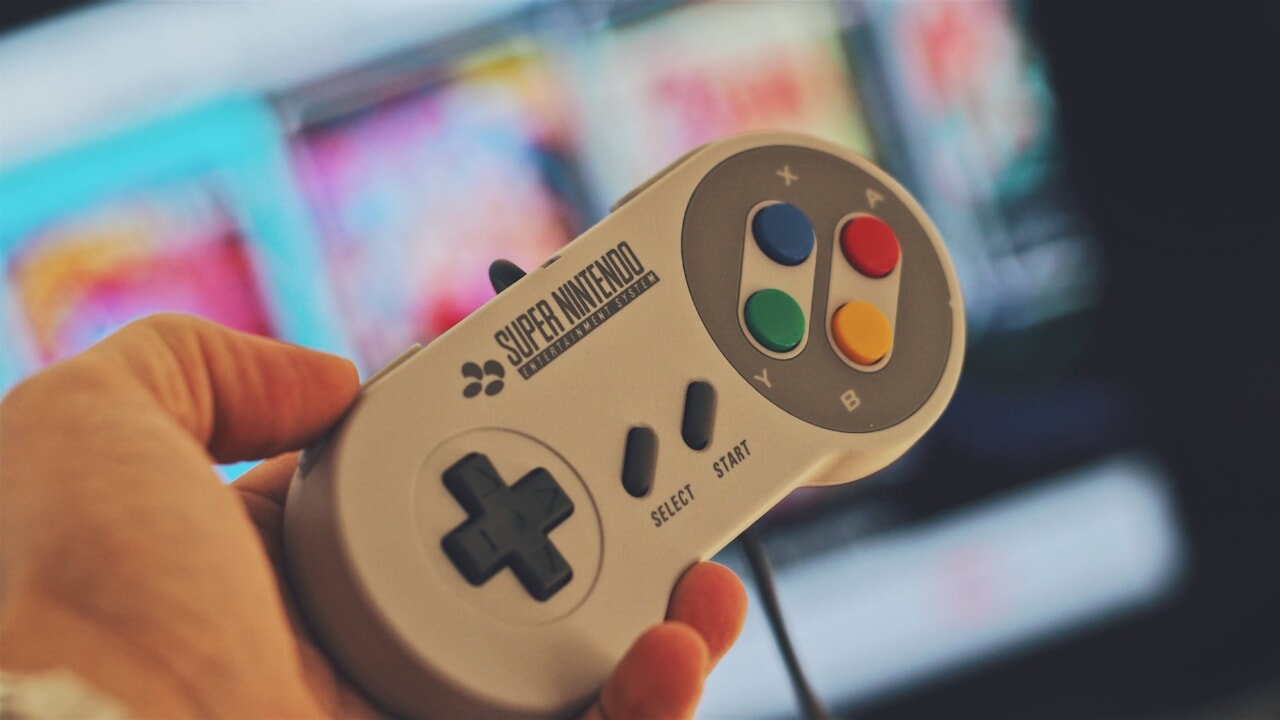 person holding white snes controller